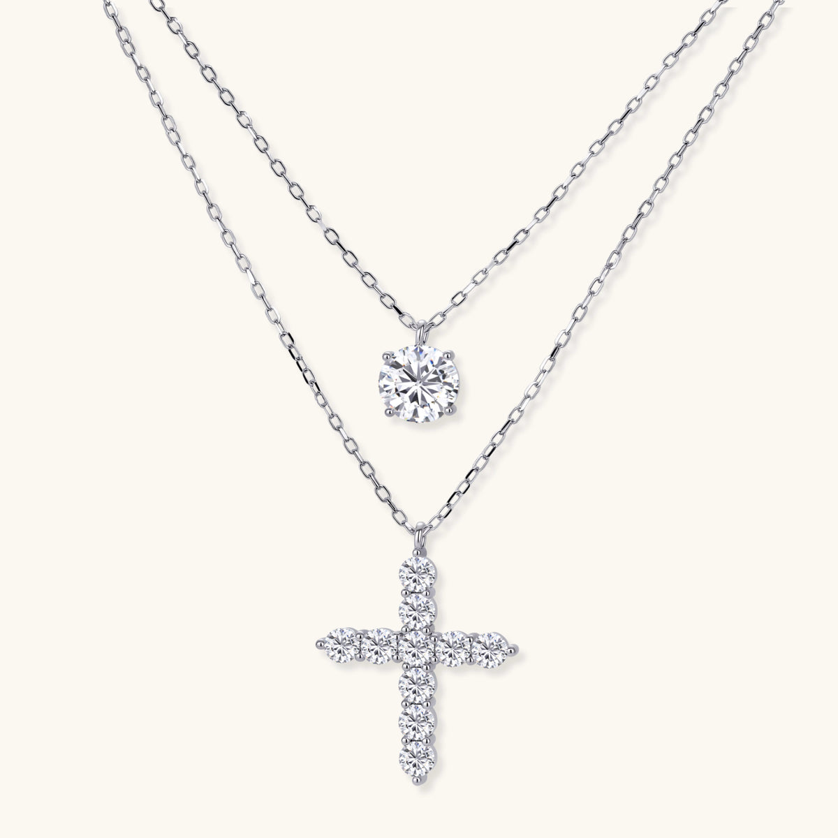 Two delicate sterling silver necklaces with moissanite stones - one solitaire pendant and one cross pendant on white background.