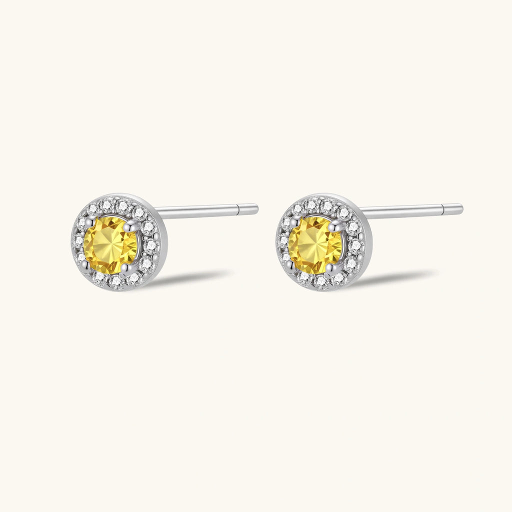 Dainty sterling silver stud earrings with yellow moissanite center stones surrounded by white halo stones