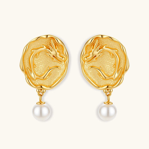 Ornate gold-plated dragon medallion earrings with white shell pearl drops on beige background, featuring detailed Chinese motifs.