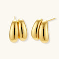 Chunky 18K gold-plated sterling silver hoop earrings with flowing sculptural curves on white background.